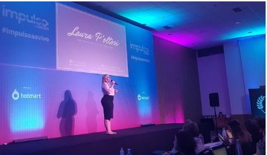 Laura Poltosi palestrando no palco do evento Impulso, da Hotmart.